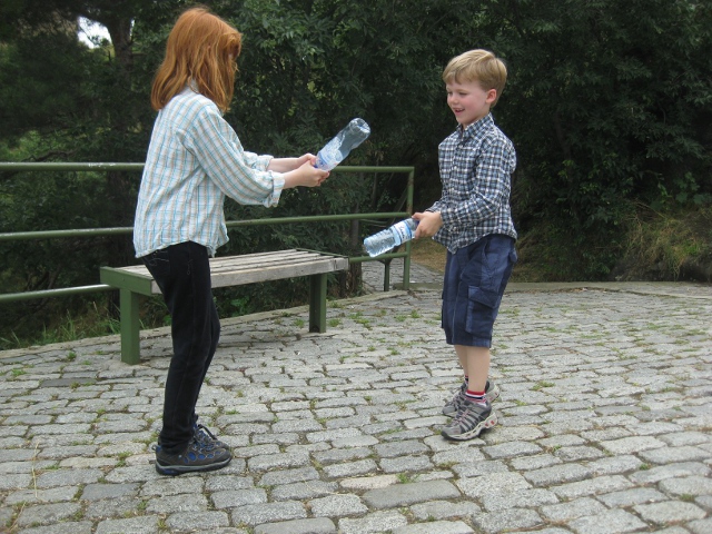 Kids fencing with water bottles